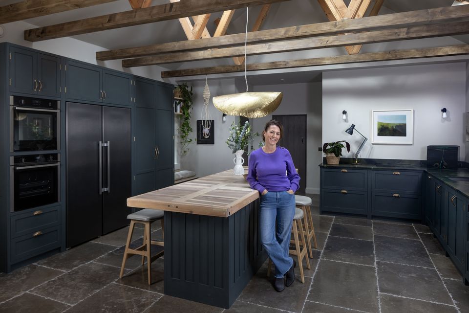 Graphic artist/interior designer Carla Benedetti in the large kitchen of her home in the Wicklow mountains. The kitchen units are from Dunne’s Design in Wicklow. She added glamour by installing a bronze light pendant by Paola Navone. Photo: Tony Gavin
